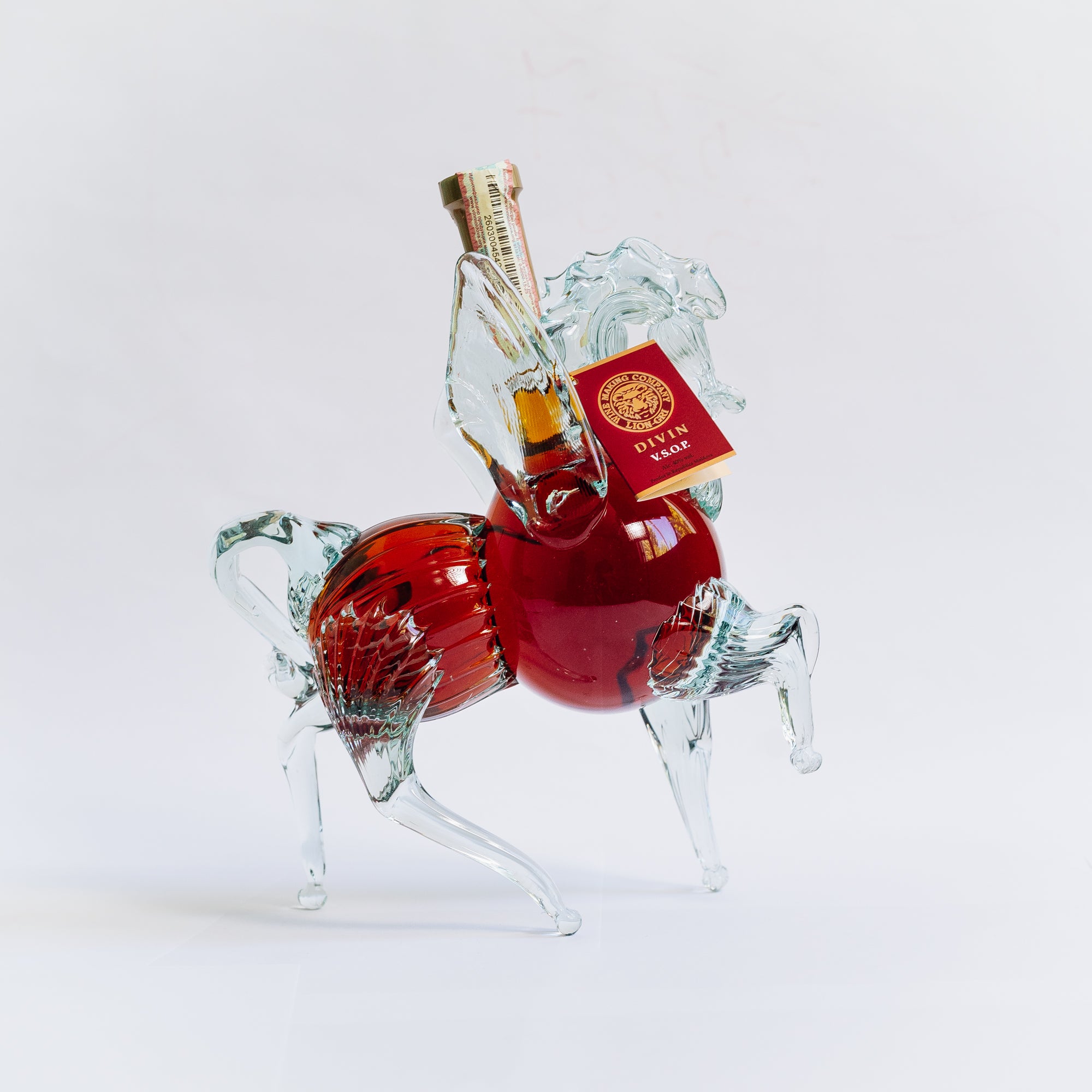 Divin VSOP Pegas Lion-gri 500ml, suport sticlă clar, decorativ, detalii roșii.