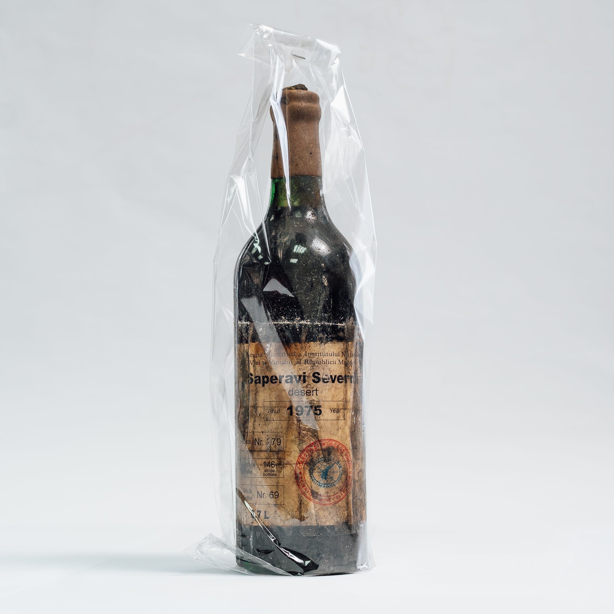Sticlă vin Saperavi Severnii Desert 1975, brand Lion-gri, ambalată în folie transparentă.